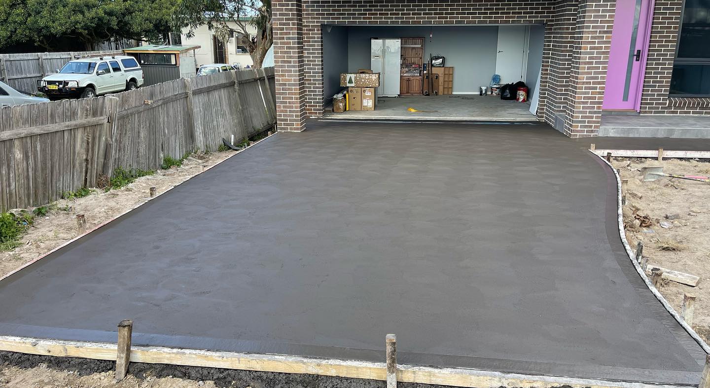 Fresh concrete driveway pour in front of a modern home