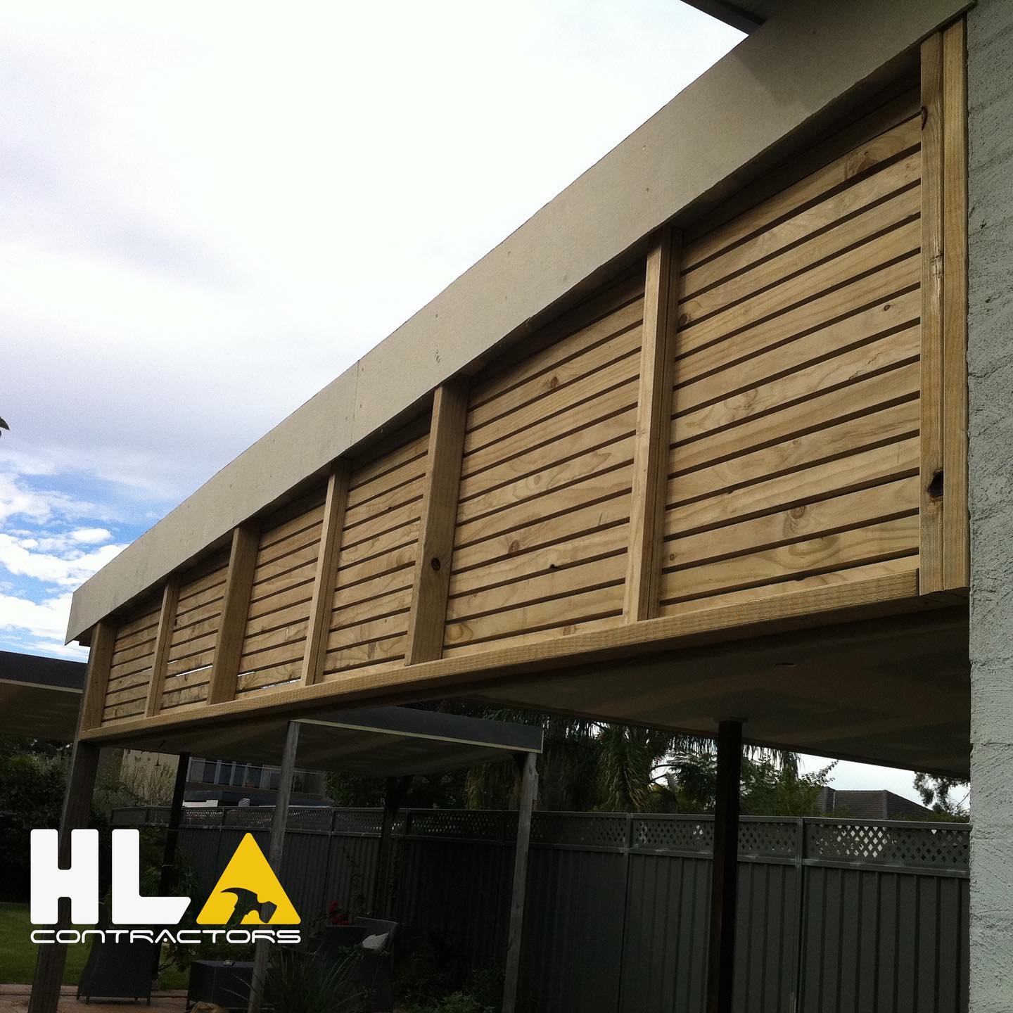 Horizontal timber slat privacy screen fixed under an outdoor roofline