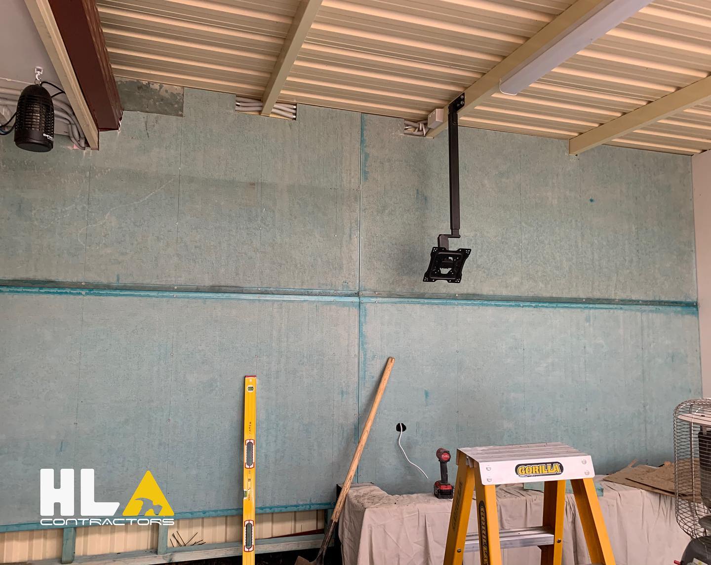 Interior fit-out with panelled walls, ladder, and power tools on site