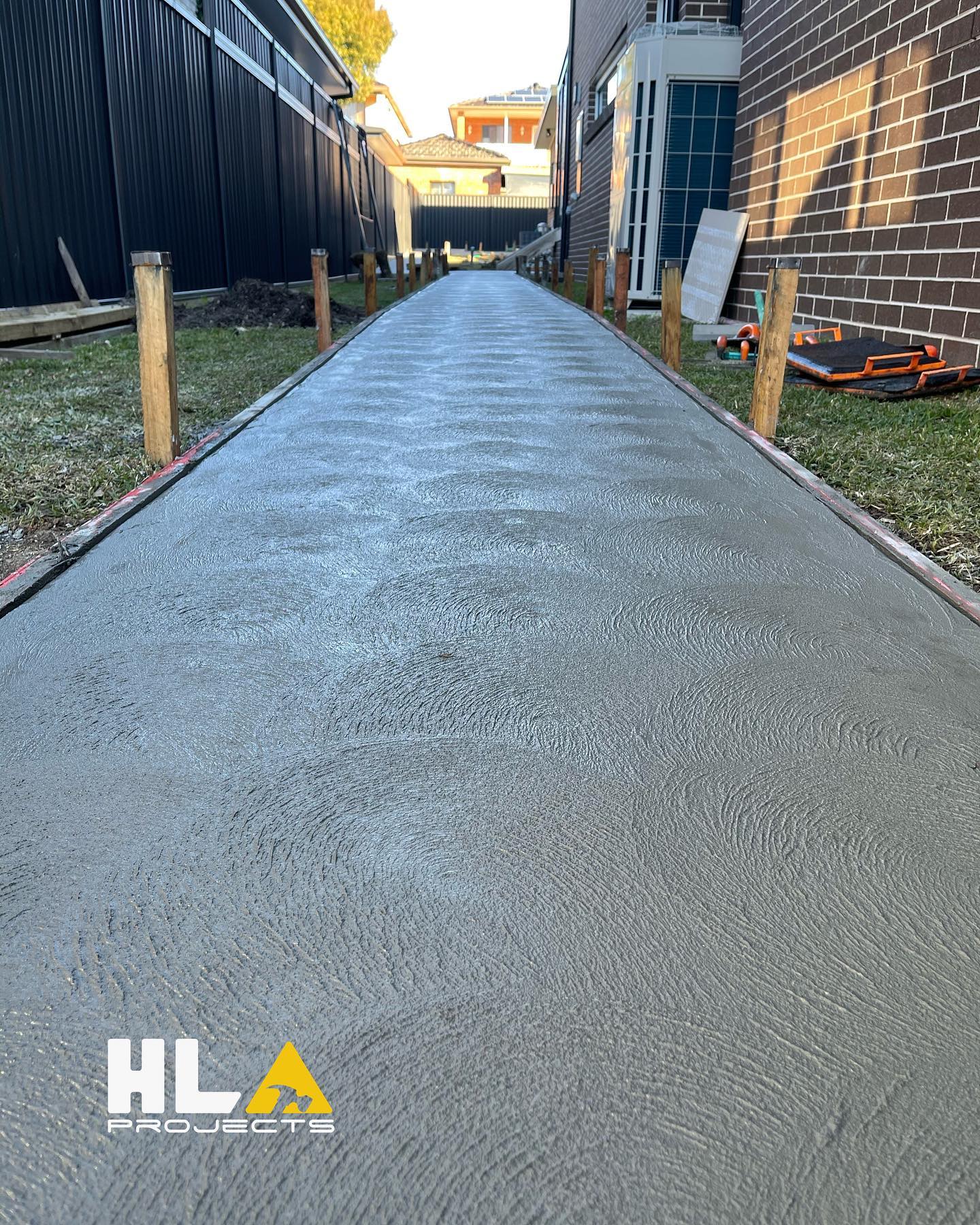 Freshly finished concrete path with timber formwork in a residential side yard